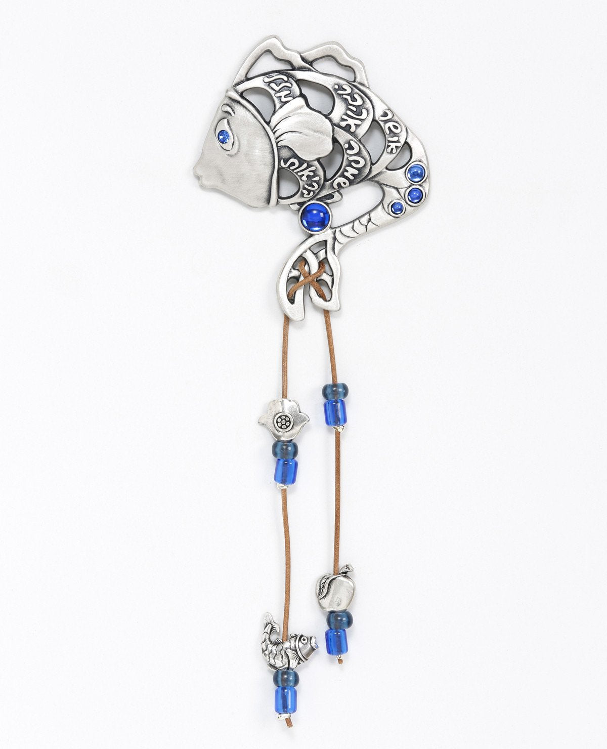 A graceful, sweet and blessed hanging wall ornament in the shape of a fish which is also a mermaid. The ornament is coated in sterling silver and embedded with blue colored beads. The fish eye is inlaid with a blue Swarovski crystal. Engraved in between the hollow parts of the fish are heartwarming words of blessing - luck, health, joy, love and happiness. Two strings made from faux leather drop from the fish tail and are decorated by fish motifs, an apple and a Hamsa, along with blue colored beads. Blessed