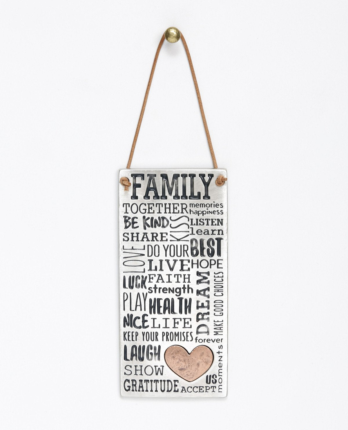 The beautiful words, charming blessings and enlightening expressions that turn any family into a united, happy, and loving one. A wonderful and special gift for your family or for the one you love. This rectangular wall pendant is modernly designed with a typographic engravement done by hand, coated in sterling silver and combined with a copper heart. Hangs from a natural colored faux leather string. Length: 14 cm Width: 6 cm