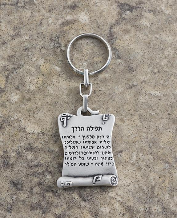 A beautiful keychain designed in the shape of a scroll, on one side the Traveler's Prayer is inscribed in Hebrew and on the other side in English. The keychain is coated in sterling silver, and is strong and reliable to carry your keys. Send your prayer for safe travels permanently, to those close to you that go far away, in Israel and abroad. They will enjoy both sides. Length: 5 cm Width: 4 cm