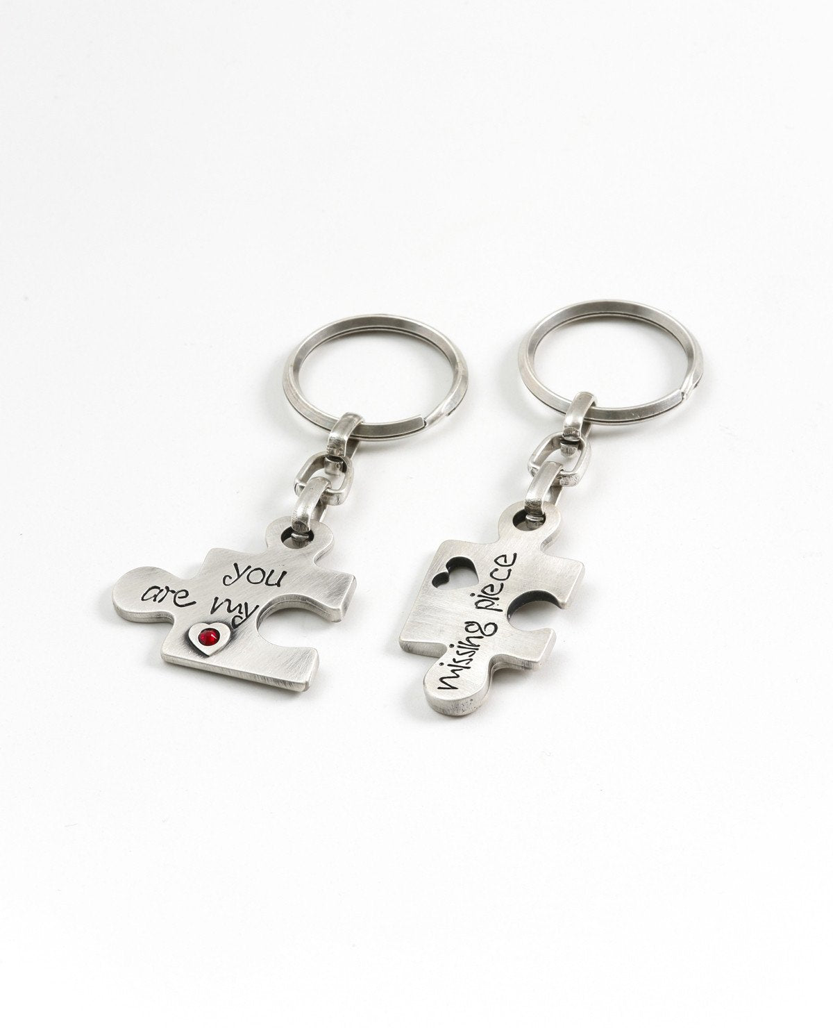 A pair of originally designed keychains, surprising and exciting, coated in sterling silver. The keychains are designed as two pieces of a puzzle that complete each other. On each keychain part of a love sentence is inscribed, with the completing bit on the other piece. The keychains are embedded with colorful Swarovski crystals. Will you find your missing piece of the puzzle? Or grant it as a gift of love to your favorite couple? We warmly recommend either! Length: 6 cm Width: 4 cm