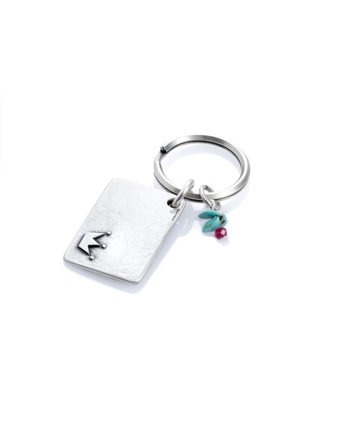 A majestic and meaningful keychain, intended specifically for your queen. Designed as a rectangle coated in sterling silver, with the word "Queen" written on one side, along with an embossed crown. On the other side is an embossed crown. Next to the rectangle hang three colorful beads. The keychain is strong and reliable. Makes a great gift that says it all, for the queen who is only yours. Length: 3 cm Width: 4 cm