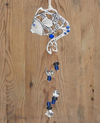 A graceful, sweet and blessed hanging wall ornament in the shape of a fish which is also a mermaid. The ornament is coated in sterling silver and embedded with blue colored beads. The fish eye is inlaid with a blue Swarovski crystal. Engraved in between the hollow parts of the fish are heartwarming words of blessing - luck, health, joy, love and happiness. Two strings made from faux leather drop from the fish tail and are decorated by fish motifs, an apple and a Hamsa, along with blue colored beads. Blessed