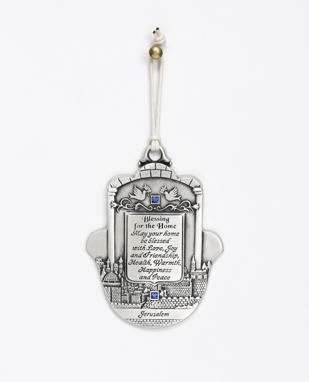 An impressively designed and uniquely decorated Hamsa hanging ornament coated in sterling silver. Decorated with an embossed image of Jerusalem and a pair of peace doves with an olive branch, alongside blessing words of love, joy, laughter and light for the home. Makes a thoughtful and loving gift that will brighten up any house. The Hamsa is embedded with blue Swarovski crystals and a natural colored faux leather string. 
Additional languages available: Hebrew and Russian.  Length: 13 cm  Width: 10 cm