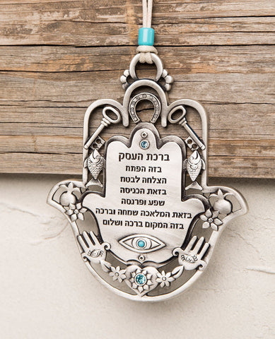An impressive and richly designed Business Blessing Hamsa for hanging, coated in sterling silver and embedded with turquoise Swarovski crystals. The Hamsa comes as a frame and is decorated with motifs of luck, abundance and a blessing for the business with a plate at the center featuring blessings of wealth and livelihood. At the bottom of the plate is an engraved eye embedded with a turquoise crystal, to protect against the "evil eye". A wonderful and exciting gift for anyone with a new or existing busines