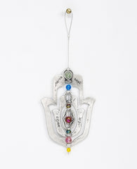 An impressive and neatly designed hanging Hamsa ornament coated in sterling silver. Set on an axis inside a large Hamsa is a smaller Hamsa. The axis is made from a thin string coated in silver and decorated by colorful beads. The ornament spins on the axis, and on each side appear different words of blessing. The qualities of the Hamsa on one side and the power of the words respectively on the other. A great gift that is also a joyful and heartwarming blessing, for any occasion. The ornament comes with a fa
