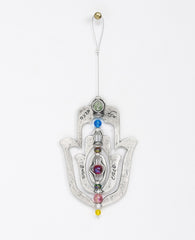 An impressive and neatly designed hanging Hamsa ornament coated in sterling silver. Set on an axis inside a large Hamsa is a smaller Hamsa. The axis is made from a thin string coated in silver and decorated by colorful beads. The ornament spins on the axis, and on each side appear different words of blessing. The qualities of the Hamsa on one side and the power of the words respectively on the other. A great gift that is also a joyful and heartwarming blessing, for any occasion. The ornament comes with a fa