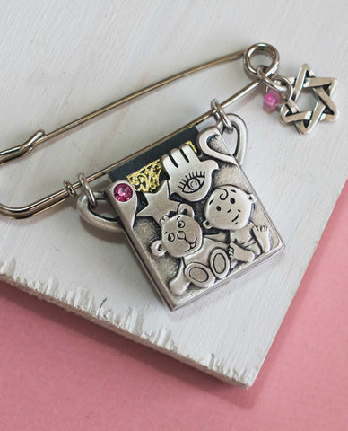 Baby carriage pin with Tehilim. Embedded with Swarovky crystal.  Length: 7 cm  Width: 5 cm