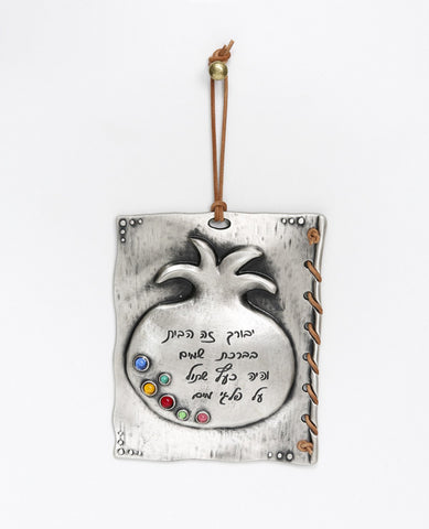 Amazing in all its beauty, this hanging Home Blessing ornament is shaped as a plate placed upon an embossed pomegranate, with a faux leather string woven around the edges. The ornament is coated in sterling silver and embedded with colorful stones. The words "He will be like a tree planted by the streams of water" engraved on the plate are taken from the book of Tehillim and bring the receiver of the gift abundance, success and both material and spiritual blessings. The hanging pomegranate is a unique gift 