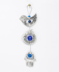 A graceful seven blessings hanging ornament coated in sterling silver, that brings joy and blesses. The ornament is made up from three motifs from the world of charms: a bird, a pomegranate and a Hamsa. All are connected to each other by a thin silver coated string decorated by blue beads, with a loop at the end for hanging. Each motif is designed with unique decorative embossments, and together create a charming and harmonic whole. Written on each one of the shapes are words of blessing, in Hebrew on one s