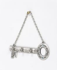 An elegant and practical key shaped hanging ornament that comes complete with hooks for hanging. The key has an antique design and is decorated with delicate graphic elements in black and embedded with turquoise colored beads. The key can be hung on the wall with the pretty and massive chain which is connected to it, allowing to adjust the ornament to hang at the desired length. The key symbolizes a successful start on a new journey. Makes a great gift to celebrate anything new in the life of our family mem