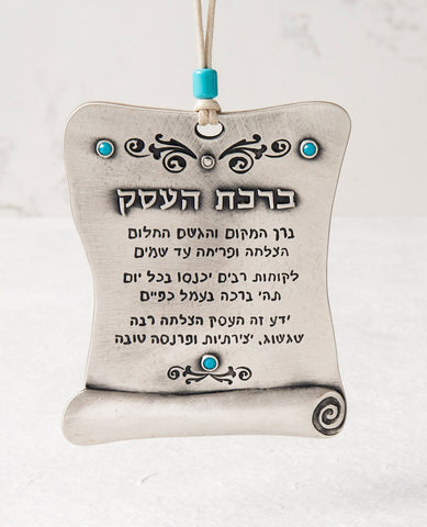An originally designed hanging Business Blessing plate, coated in sterling silver and embedded with turquoise colored Swarovski crystals. "Bless this place and make dreams come true..." are just some of the moving words engraved onto the blessing scroll. An authentic and beautiful gift for a new or existing business, bound to excite anyone who receives it.
The hanging ornament comes with a faux leather string decorated with a turquoise colored bead.  Length: 11 cm  Width: 9 cm