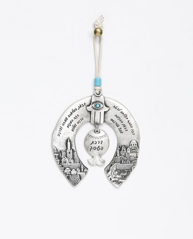 An originally and authentically designed hanging horseshoe Business Blessing. The horseshoe is decorated on both sides with an embossed image of Jerusalem. In the middle hangs a pomegranate with a Hamsa on top embedded with a turquoise colored Swarovski crystal. The hanging ornament is coated in sterling silver and decorated with blessing words for abundance, success and good fortune. Made to grant its receiver with love, good intention and a heartfelt blessing. Comes with a natural colored faux leather str