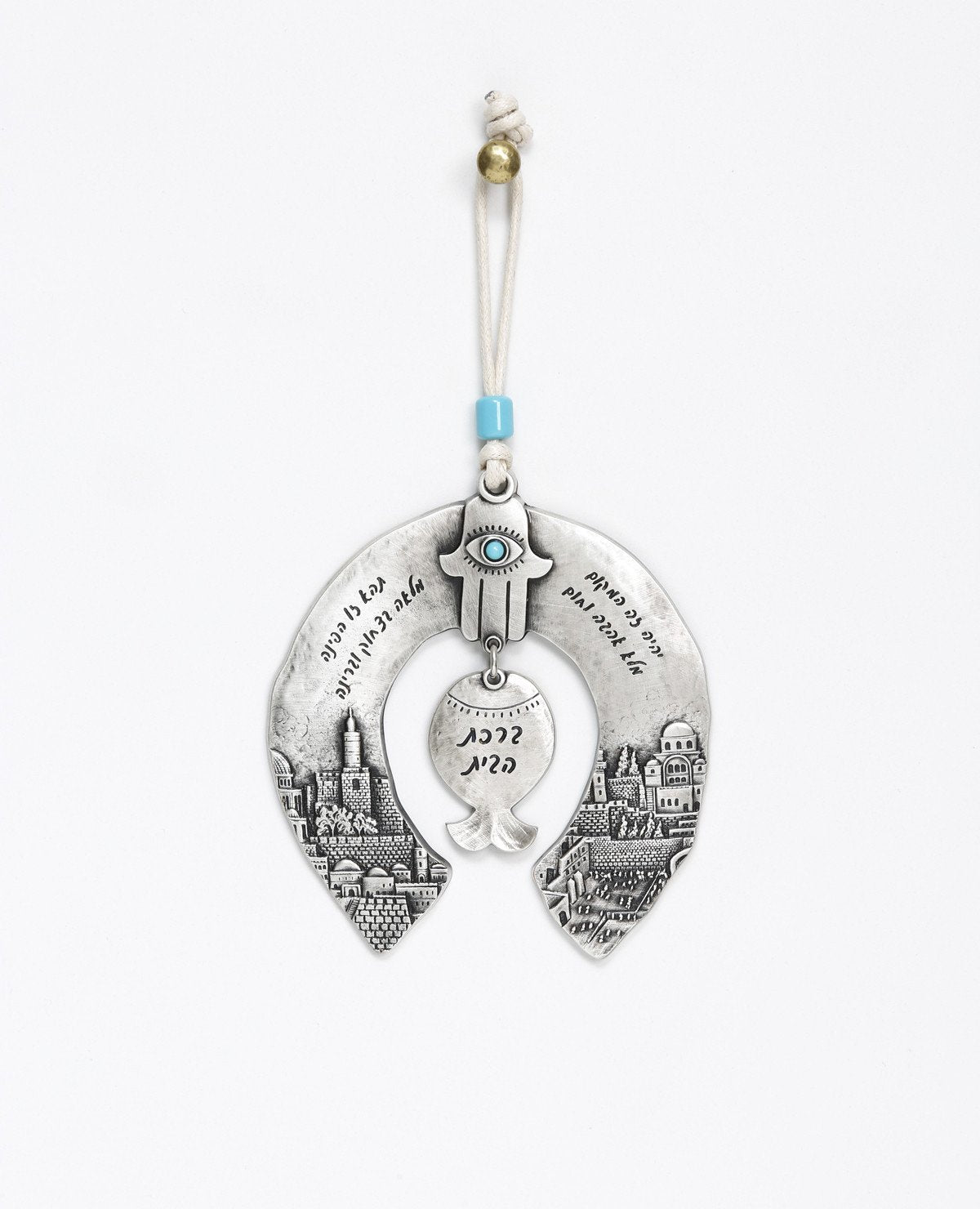 A unique and originally designed hanging Home Blessing ornament in the shape of a horseshoe. The horseshoe is embedded with an embossed image of Jerusalem on both sides. A pomegranate hangs from the center, with a Hamsa on top of it inlaid with a turquoise colored Swarovski crystal. The ornament is coated in sterling silver and decorated with words of blessing, love and light. Comes with a natural colored faux leather string decorated with a turquoise colored bead. Makes a great housewarming gift or an orig