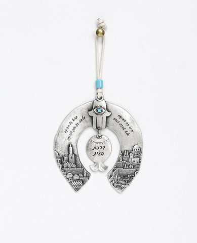A unique and originally designed hanging Home Blessing ornament in the shape of a horseshoe. The horseshoe is embedded with an embossed image of Jerusalem on both sides. A pomegranate hangs from the center, with a Hamsa on top of it inlaid with a turquoise colored Swarovski crystal. The ornament is coated in sterling silver and decorated with words of blessing, love and light. Comes with a natural colored faux leather string decorated with a turquoise colored bead. Makes a great housewarming gift or an orig