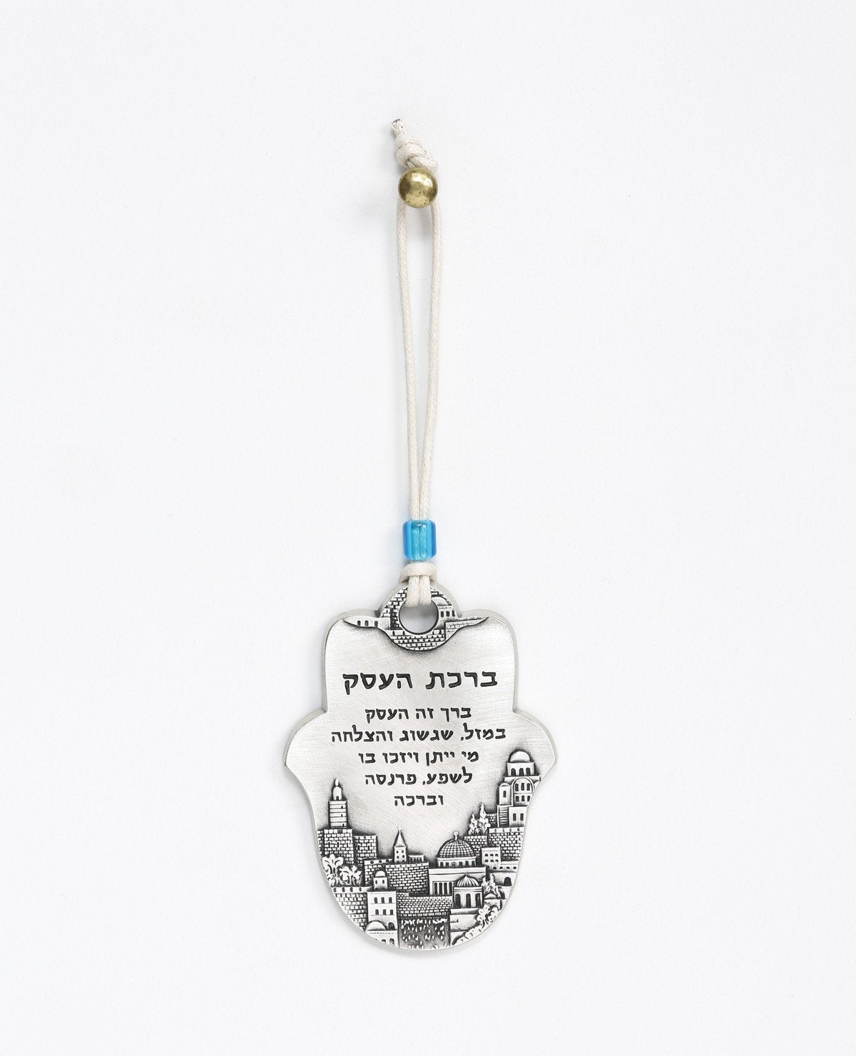 An impressive and excitingly designed hanging Hamsa Business Blessing. The Hamsa is coated in sterling silver and comes with a faux leather string  for hanging decorated by a blue bead. Engraved on the bottom part of the Hamsa an image of beautiful Jerusalem, and in the upper part appear blessing words of abundance, luck, prosperity, success and good fortune. The hanging ornament makes the perfect gift as a gesture of good intention for any business, old or new.   Length: 9 cm  Width: 6 cm