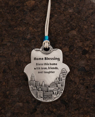 A Hamsa shaped hanging Home Blessing ornament coated in sterling silver and decorated with an embossed image of Jerusalem. The words of blessing will bestow the house with health, peace, kinship, abundance and fulfilled dreams. A joyful and thoughtful gift that blesses anyone who may receive it. Comes with a natural colored faux leather string for hanging decorated with a blue colored bead.  Additional languages available: Hebrew.  Length: 9 cm  Width: 6 cm