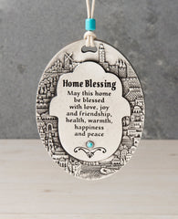 A spectacularly beautiful hanging Home Blessing ornament in English, in the shape of an oval plate. The plate is embedded around its edges with an outline of the sights of Jerusalem, and in the center a Hamsa upon which appear blessing words for love, friendship, joy, health, happiness and peace. Makes a very welcoming gift for the home intended for the people we hold dear, far or near. The hanging ornament is coated in sterling silver and embedded with a turquoise colored Swarovski crystal. Comes with a na