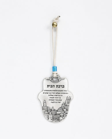 A Hamsa shaped hanging Home Blessing ornament coated in sterling silver and decorated with an embossed image of Jerusalem. The words of blessing will bestow the house with health, peace, kinship, abundance and fulfilled dreams. A joyful and thoughtful gift that blesses anyone who may receive it. Comes with a natural colored faux leather string for hanging decorated with a blue colored bead. Additional languages available: English.  Length: 9 cm  Width: 6 cm