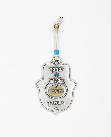 A designed hanging Hamsa ornament that carries on it the blessing of "May the Lord bless you and keep you safe", words that were added to the Kohen's blessing out of Jacob's blessing before his death to Joseph's sons - Ephraim and Manasseh. The Hamsa is coated in sterling silver combined with brass and has the blessed sentence embossed. Embedded at the center is a blue Swarovski stone and a pair of doves with an olive branch. At the top and bottom of the Hamsa are Stars of David. The Hamsa hangs from a natu