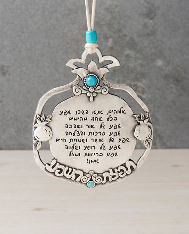 A beautiful and enlightening pomegranate hanging ornament that is all a blessing for abundance. An abundance of light and love, success, happiness and joy, peace and serenity, health and luck. The pomegranate is coated in sterling silver and designed as a plate surrounded by a hollow frame which is decorated by two small pomegranates and the words "Prayer of Abundance" appearing in the center. The prayer for abundance is engraved on the plate in the center of the pomegranate. The pomegranate has a double cr