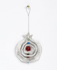 A pomegranate hanging ornament with a unique design that grants it motion which hypnotizes the eye with beauty. The pendant is designed in the shape of a hollow pomegranate with circular shapes at its center which are thread around one central axis, with colorful beads between them. The pendant is coated in sterling silver and hangs from a thin and strong silver string. Always suitable as a unique gift, embodying within it the pomegranate's blessing of abundance and fertility. Especially suitable around Ros