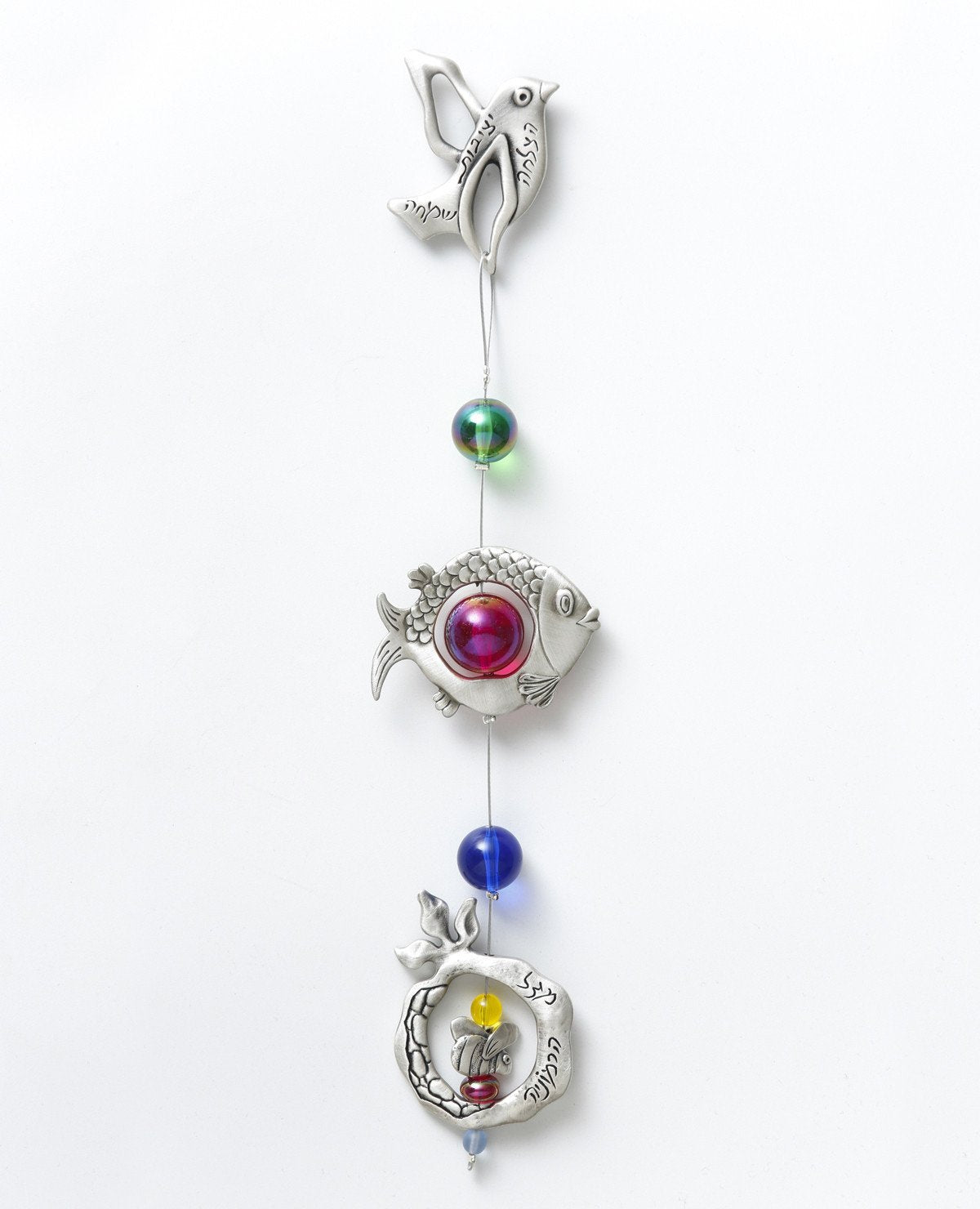 A delicate and beautiful hanging wall ornament, bringing together a few blessing motifs: a bird, a fish and a pomegranate, all hanging from a subtle silver string. The ornament is coated in sterling silver and is decorated with colorful beads. The bird and pomegranate are engraved with words of blessing for harmony, luck, success, stability, and joy. Makes a charming gift for any occasion and for anywhere in the house or office. It's so pleasant to gaze at this lovely ornament and smile every moment with gr
