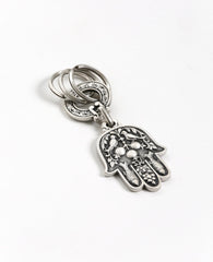 A double sided Hamsa keychain coated in sterling silver. On one side is a big eye embedded with a blue colored Swarovski crystal and embossed lions. On the other side are embossed birds, pomegranates, fish and grapes. The whole Hamsa is decorated in a filigree like style. The connecting links and the key rings are massive and strong. It's fun to connect our most important keys to it and most definitely to grant our loved ones with such a beautiful Hamsa, blessed with the many icons of good fortune, protecti