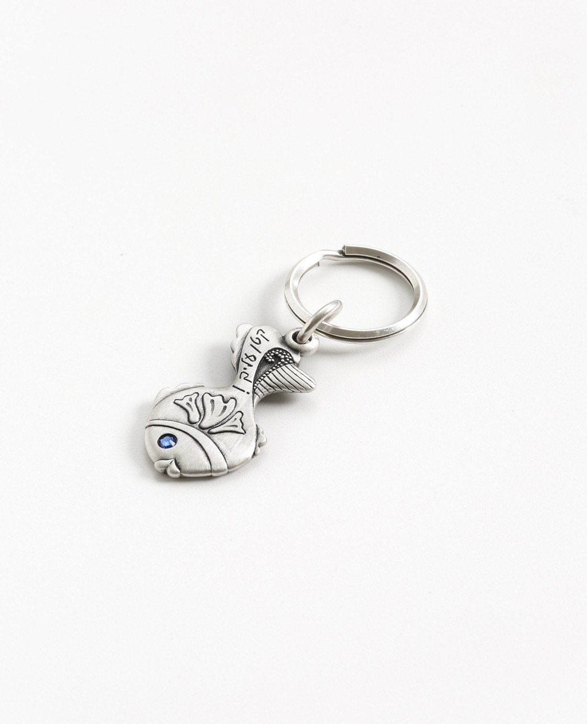 A small fish keychain with the words "easy for you!". The word 'easy' is coated in sterling silver and embedded with a blue colored Swarovski crystal. The design is sweet and elegant, plus it's fun to pull out of your pocket with all your keys safely attached. Together with a loving smile, it makes a great gift to give to those that matter to us, in order to remind them how talented and capable they are in accomplishing anything they may choose. The luck is already inside.   Length: 5 cm  Width: 2 cm