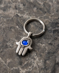 A small Hamsa shaped Chai keychain that carries a blessing with it. 
On one side of the keychain is a Hamsa decorated with a round blue colored stone, and on the other side the blessed "Chai" letters are engraved, symbolizing protection.
Makes a joyful gift for any occasion and for anyone who we may want the keys to their life be kept on a blessed and beautiful keychain like this one.  Length: 4 cm  Width: 2 cm