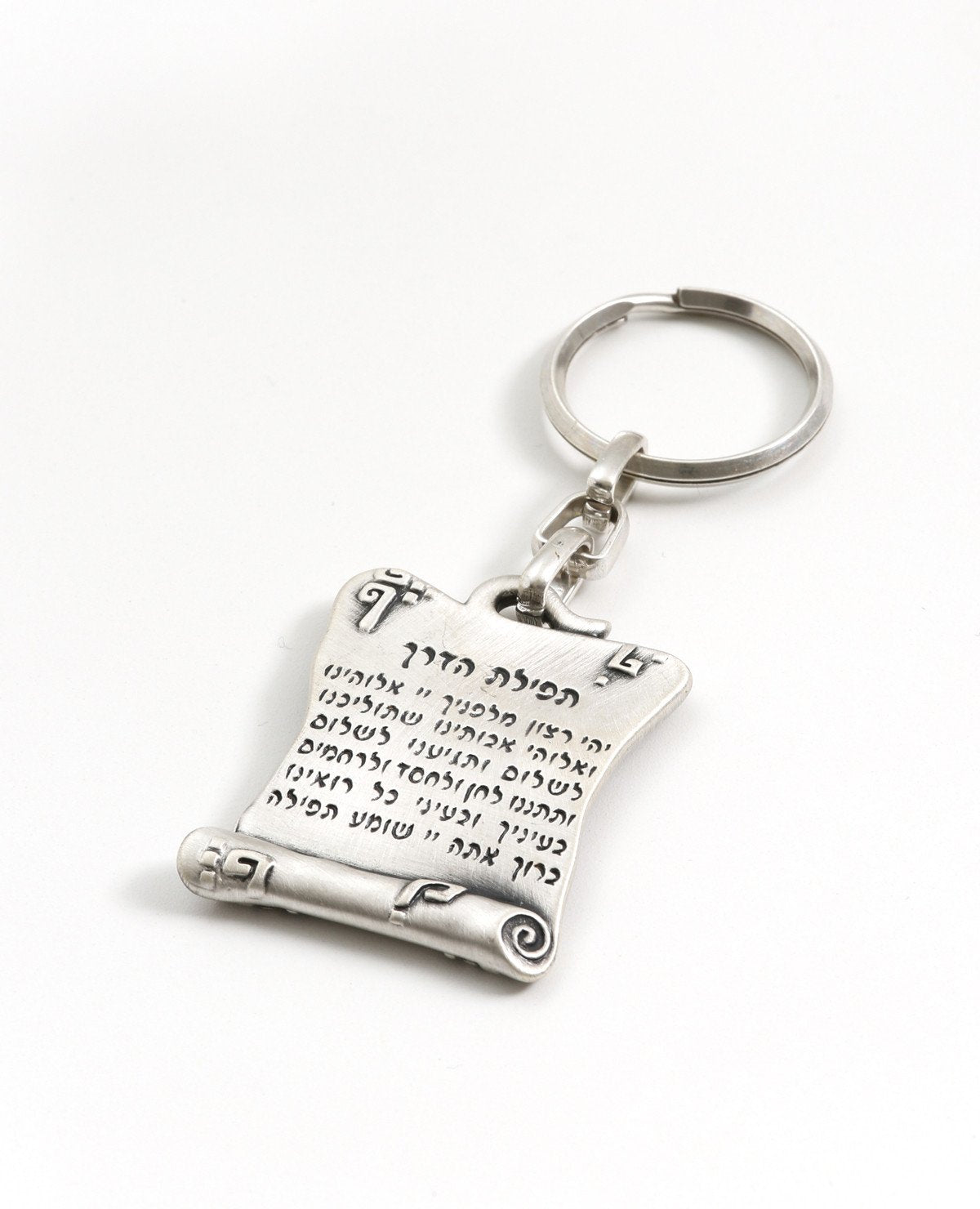 A beautiful keychain designed in the shape of a scroll. On one side the Traveler's Prayer is inscribed and on the other side an embossed Hamsa decoration. The keychain is coated in sterling silver and is strong and reliable to carry your keys. "Lead us in peace and return us in peace" - bless and feel blessed with this wonderful keychain.  Length: 5 cm  Width: 4 cm