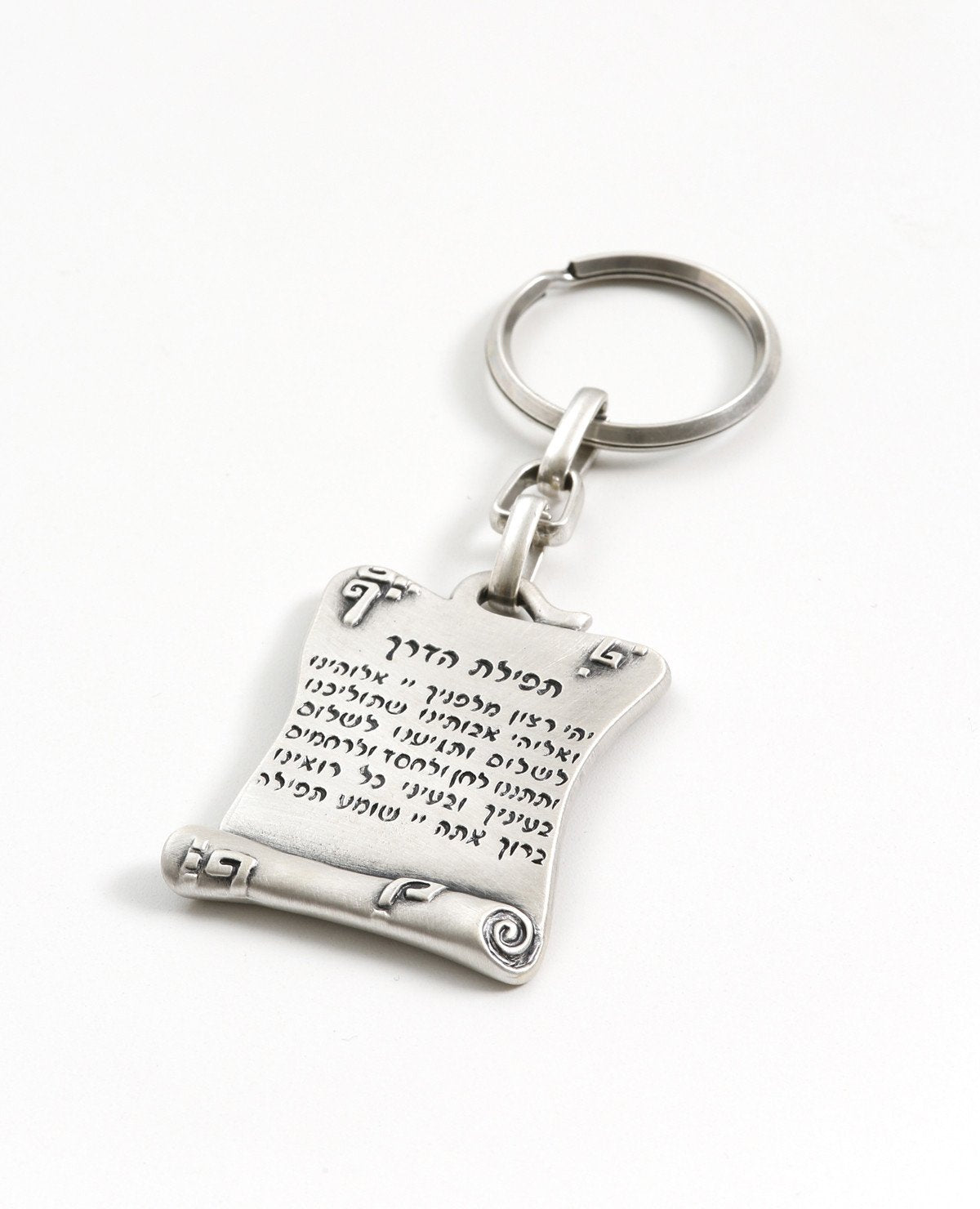 A beautiful keychain designed in the shape of a scroll, on one side the Traveler's Prayer is inscribed in Hebrew and on the other side in English. The keychain is coated in sterling silver, and is strong and reliable to carry your keys. Send your prayer for safe travels permanently, to those close to you that go far away, in Israel and abroad. They will enjoy both sides.  Length: 5 cm  Width: 4 cm