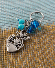For those who like to "swim against the current" and you wish for them to "swim" safely and happily to any place they wish! A keychain with a fish element at its center, one of the symbols of abundance and luck. Artistically cut and combined with a sterling silver coated Hamsa with "drops" of turqoise beads around it resembling the sea of endless possibilities. Comes also in your choice of colorful colored stone.  Length: 9 cm  Width: 4 cm