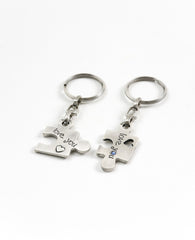 A pair of originally designed keychains, surprising and exciting, coated in sterling silver. The keychains are designed as two pieces of a puzzle that complete each other. On each keychain part of a love sentence is inscribed, with the completing bit on the other piece. The keychains are embedded with colorful Swarovski crystals. Will you find your missing piece of the puzzle? Or grant it as a gift of love to your favorite couple? We warmly recommend either!  Length: 6 cm  Width: 4 cm
