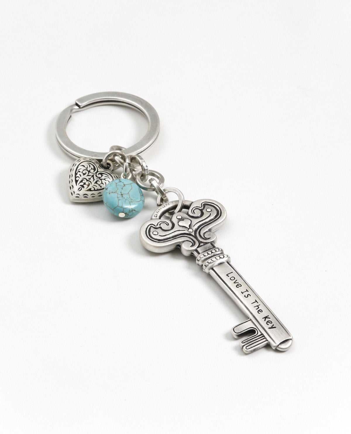 Love is the key to everything! Always! A keychain that is all love. Designed as a large and impressive key decorated with embossed artistic elements and tiny hearts. On one side the sentence "Love Is The Key" is engraved, and on the other side the sentence "The Key To My Heart". Connected to the top of the key is a chain with a sweet heart and a beautiful turquoise stone hanging upon it. The keychain is coated in sterling silver and is strong and reliable. An exciting gift for those still searching for the 