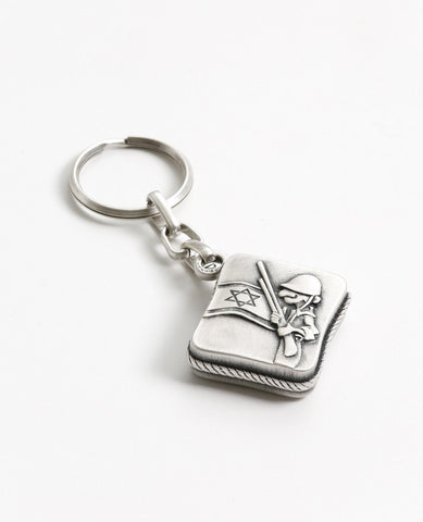 All the love, worry, values and protection in one place. The keychain is designed in the shape of a box, within it a small book of Tehillim for the way. Embossed on one side of the keychain is a hollow Hamsa, which the book can be seen through, and the words "protect my soldier" engraved at its base. On the other side is an embossed caricature of a soldier on guard next to a flag of Israel. The keychain is coated in sterling silver and is strong and reliable. Make sure it is always in your soldier's pocket!