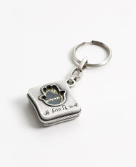 All the love, worry, values and protection in one place. The keychain is designed in the shape of a box, within it a small book of Tehillim for the way. Embossed on one side of the keychain is a hollow Hamsa, which the book can be seen through, and the words "protect my soldier" engraved at its base. On the other side is an embossed caricature of a soldier on guard next to a flag of Israel. The keychain is coated in sterling silver and is strong and reliable. Make sure it is always in your soldier's pocket!