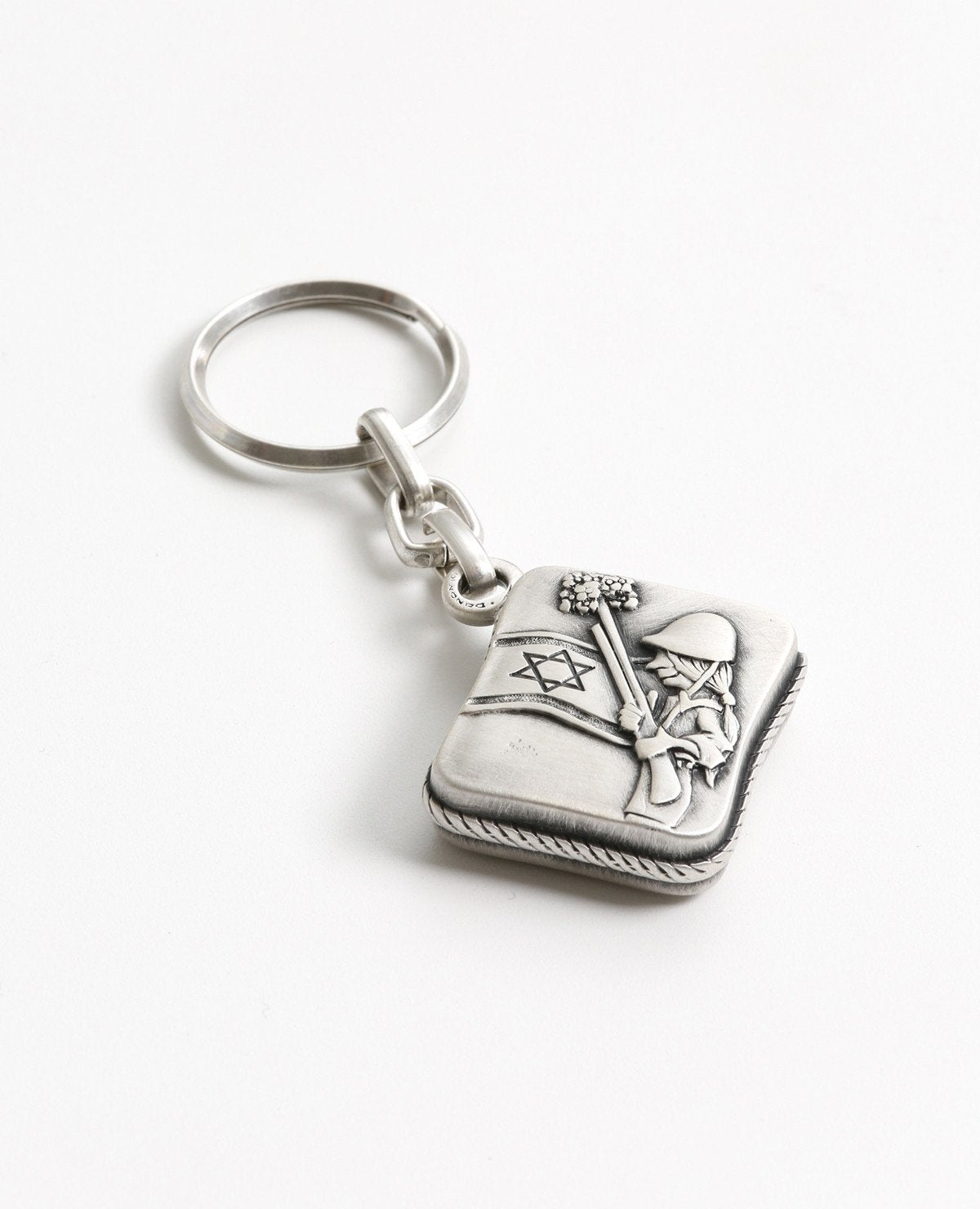 All the love, worry, values and protection in one place. The keychain is designed in the shape of a box, within it a small book of Tehillim for the way. Embossed on one side of the keychain is a hollow Hamsa, which the book can be seen through, and the words "protect my soldier" engraved at its base. On the other side is an embossed caricature of a female soldier on guard next to a flag of Israel. The keychain is coated in sterling silver and is strong and reliable. Make sure it is always in your soldier's 