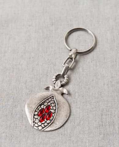 It's impossible to not marvel over its sheer beauty. The keychain is designed as an artistic and unique looking pomegranate. On one side is an embossed image of a pomegranate sliced open to show its seeds, with red stones in the shape of the seeds. Engraved on the other side is the blessing: "abundance, blessing and success on your journey". The pomegranates virtue of abundance and privilege always accompanies whoever will carry their keys on this charming keepsake. The keychain is coated in sterling silver