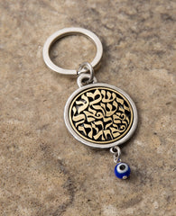 A keychain that touches the soul of any Jew. Designed as a circle, with the embossed words "Hear O Israel, the Lord our god, the Lord is one" in brass coated letters on a black background on one side. Engraved on the other side is the sentence "with the greatness​ of thy powerful right hand", decorated by a Hamsa with an eye. At the bottom of the circle hangs a blue eye - against the "evil eye". The words "Shema Israel" remind the people of Israel that God is the one and only and is regarded in Judaism as t