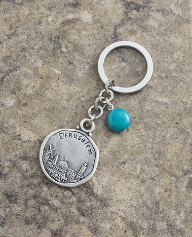 An exciting keychain that keeps Jerusalem close to us at all times. Designed as a circle, on one side appears the Jerusalem landscape as well as the word "Jerusalem", and on the other side another view of Jerusalem. Connected to the top of the circle is a chain with a beautiful turquoise stone hanging from it. The keychain is coated in sterling silver and is strong and reliable. Makes a great gift for family and friends in Israel and abroad who we wish to grant with a souvenir from our one and only Jerusale
