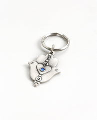 A extraordinarily beautiful keychain with a rare design, coated in sterling silver. On one side of the Hamsa is a dove inlaid with a blue colored Swarovski crystal. Engraved on top is the Kohen's blessing "May the Lord bless you and keep you safe". On the other side of the Hamsa are two doves looking in opposite directions, with a heart in between them that is also embedded with a blue stone. A keychain that is all beauty and blessings. The Hamsa's blessing for good luck, the doves blessing for peace and lo