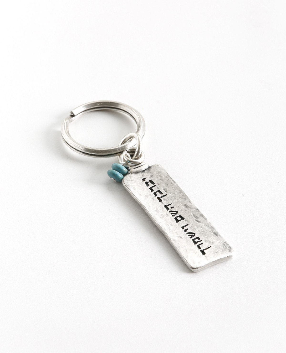 A keychain with a classic look, designed as a two-sided rectangular plate. Written on one side is the passage "May the Lord bless you and keep you safe", and on the other side appear decorations of good luck - a Star of David, a Hamsa with an eye, and a fish. In between the charms the words "Luck" and "Hamsa on you" are written. At the top of the rectangle hang two round turquoise colored stones, to complete the perfect look. 
The keychain is coated in sterling silver and is strong and reliable. 
A great pr