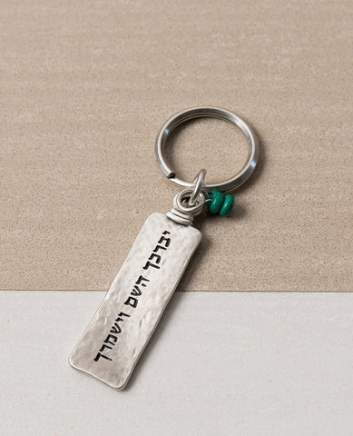 A keychain with a classic look, designed as a two-sided rectangular plate. Written on one side is the passage "May the Lord bless you and keep you safe", and on the other side appear decorations of good luck - a Star of David, a Hamsa with an eye, and a fish. In between the charms the words "Luck" and "Hamsa on you" are written. At the top of the rectangle hang two round turquoise colored stones, to complete the perfect look. 
The keychain is coated in sterling silver and is strong and reliable. 
A great pr