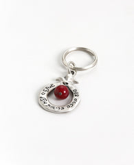 Always bless!
A charming keychain, designed as a hollow pomegranate with a big red bead in the center.
Written on one side are many blessings in Hebrew, and on the other side many blessings in English. The keychain is coated in sterling silver and is strong and reliable. 
Makes for quite the useful gift that is also festive and very blessed, suitable for both Hebrew and English speakers, near or far, in Israel and abroad. 
Comes also in your choice of turquiose colored bead.   Length: 8 cm  Width: 4 cm