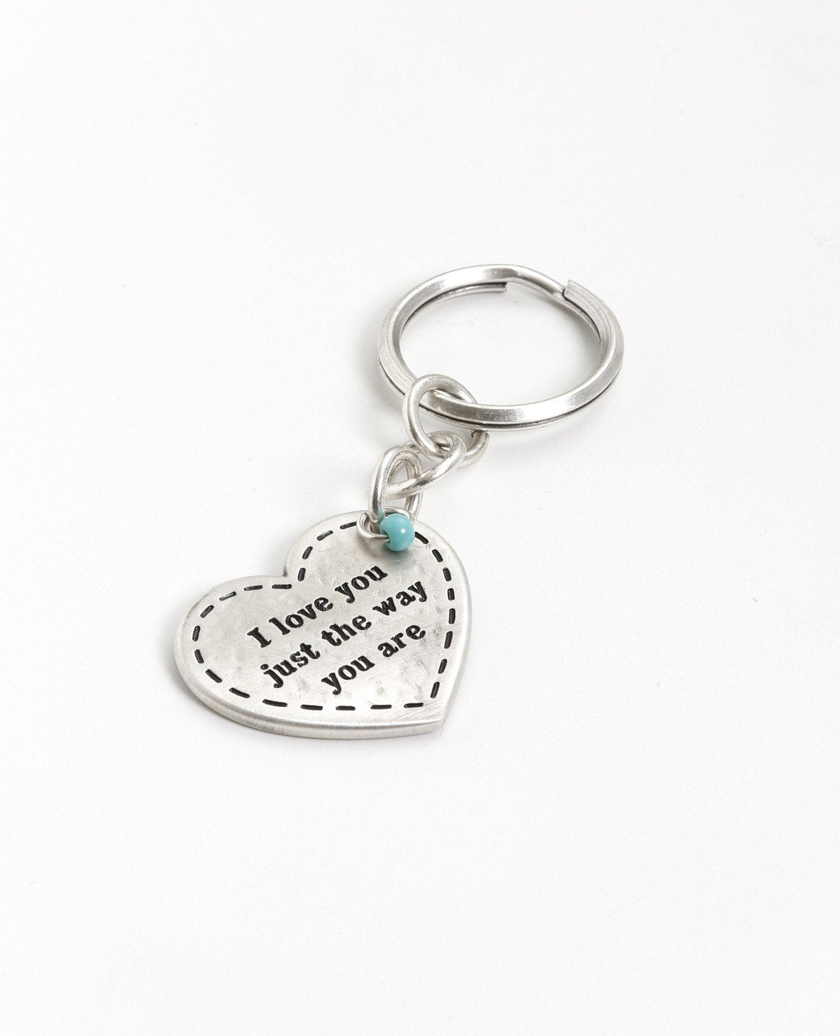 As romantic as it gets! For him and for her. A charming keychain in the shape of a decorated heart with the words "I love you just the way you are" written on one side. On the other side the word "Love" is written in different languages. At the top of the heart hangs a small turquoise colored bead. The keychain is coated in sterling silver and is strong and reliable. Can you think of anything more romantic to give to him or her? Is there anything beyond accepting our loved ones exactly as they are? 
Comes a