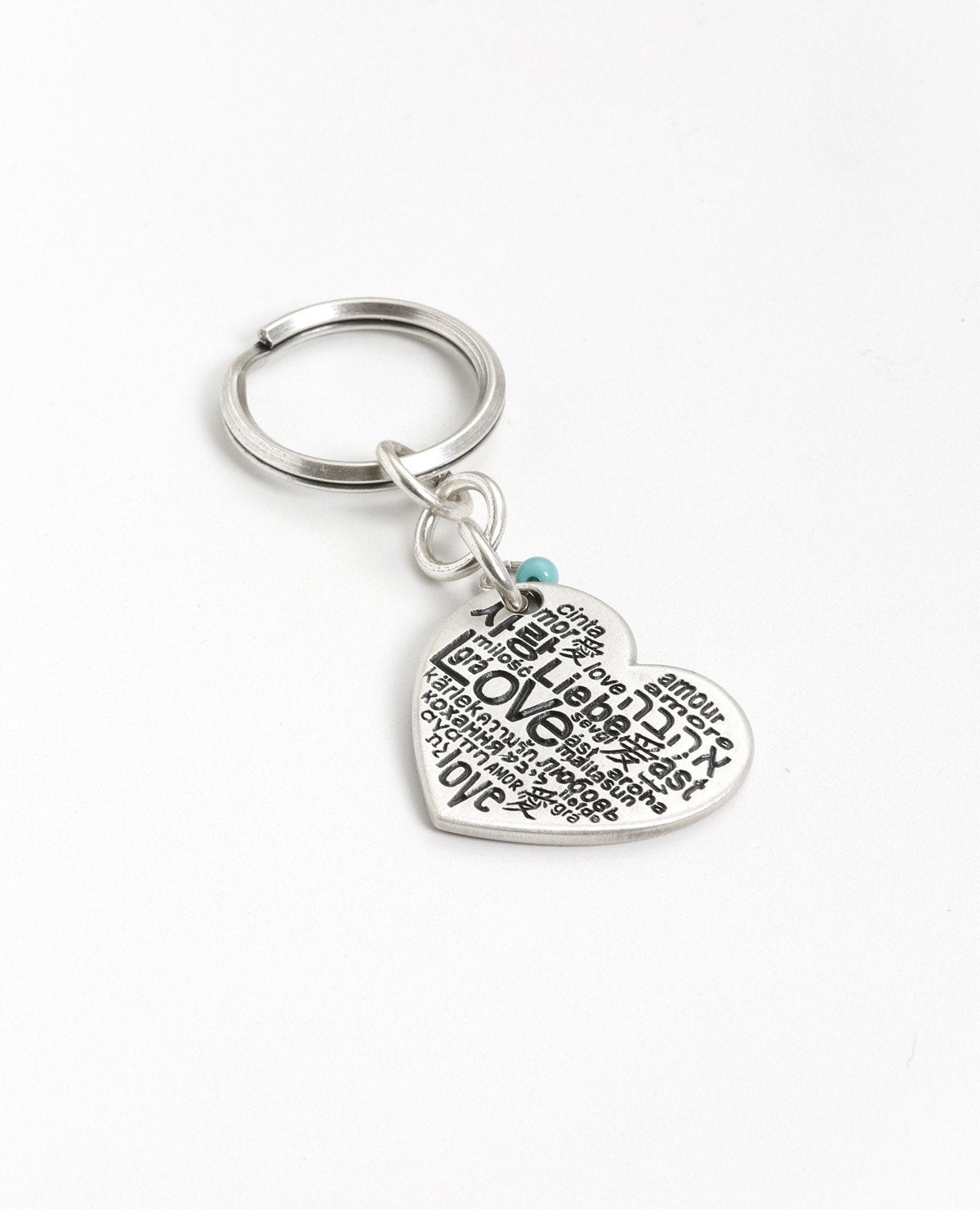 As romantic as it gets! For him and for her. A charming keychain in the shape of a decorated heart with the words "I love you just the way you are" written on one side. On the other side the word "Love" is written in different languages. At the top of the heart hangs a small turquoise colored bead. The keychain is coated in sterling silver and is strong and reliable. Can you think of anything more romantic to give to him or her? Is there anything beyond accepting our loved ones exactly as they are? 
Comes a