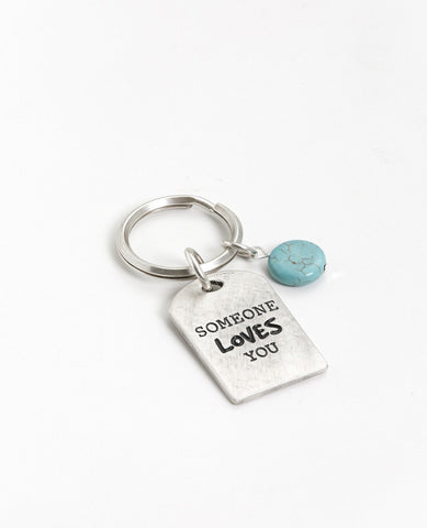 Drive carefully! Somebody loves you and cares about you. An impressive and excitingly designed keychain in the shape of a rectangular plate. One side has the words "Drive Safely" written on it, and on the other side the words "Someone loves you". Next to the plate hangs an impressive round turquoise stone. The keychain is coated in sterling silver and is strong and reliable. An exciting gift for him or for her with an important reminder: take care when driving, because somebody loves you.  Length: 7 cm  Wid