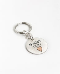 A keychain that directly touches the heart. Designed as a circle coated in sterling silver, one side has an embossed heart coated in brass with the words "Always In My Heart" written on it. The other side has drawings of tiny hearts all bunched together on the right side of the heart. The keychain is strong and reliable. Makes an exciting gift that says it all: always in my heart! Next to the beat of your heart there is always room for the heartbeat of your lover, best friend, mother, father, family member.
