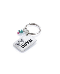 A majestic and meaningful keychain, intended specifically for your queen. Designed as a rectangle coated in sterling silver, with the word "Queen" written on one side, along with an embossed crown. On the other side is an embossed crown. Next to the rectangle hang three colorful beads. The keychain is strong and reliable. Makes a great gift that says it all, for the queen who is only yours.   Length: 3 cm  Width: 4 cm