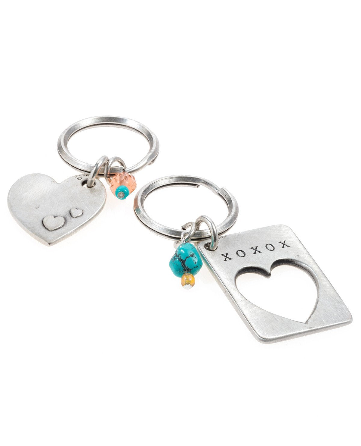 A visually remarkable and extremely romantic pair of keychains.
One is designed as a rectangle with a missing piece in the shape of a heart with the words "I Love U" written on top.
The other keychain is designed in the shape of a heart and has the words "I Love You More" written on it, perfectly completing the piece on the other keychain.
Each one of the keychains is decorated by two colorful beads.
The keychains are coated in sterling silver and are strong and reliable. 
A perfect and romantic gift for an
